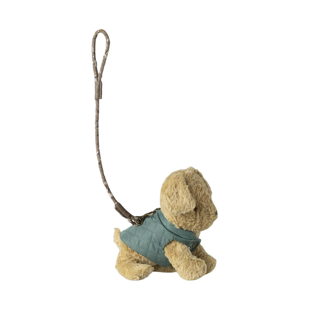 Small plush dog toy with a green jacket on a white background