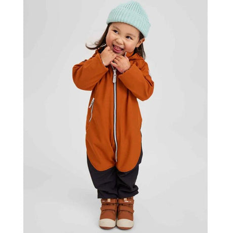 Little girl wearing brown and blue jumpsuit with matching shoes and toque