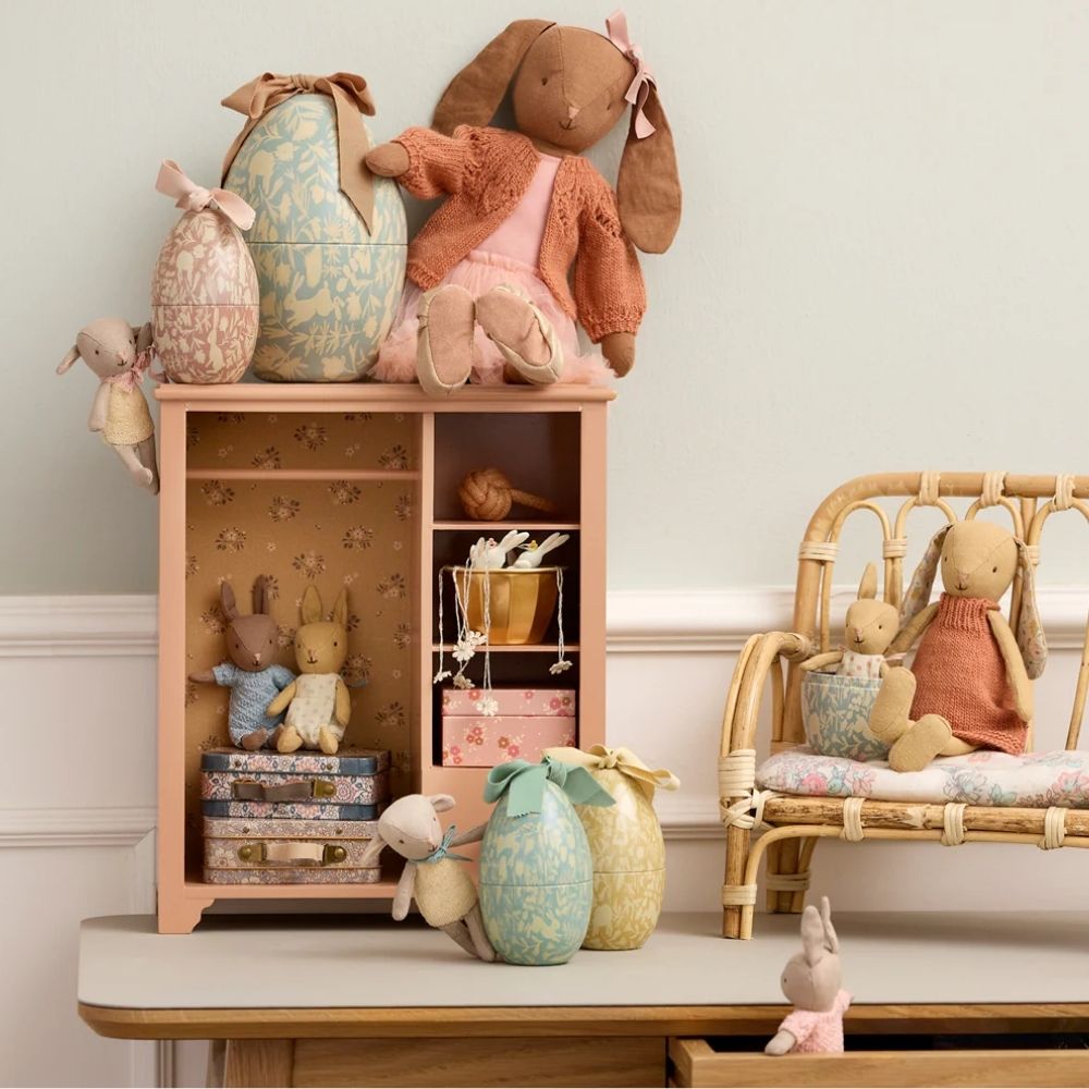 Children's room with wooden shelf and chair, filled with plush toys and decorative items.
