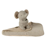 Stuffed elephant toy with a blanket on a white background