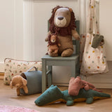 Children's room with plush toys including a lion, elephant, and bear on a chair and floor.
